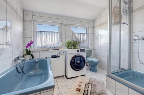 ein Badezimmer mit einer Waschmaschine und einer Badewanne in der Unterkunft Ferienwohnung Winzenburg in Rehburg-Loccum