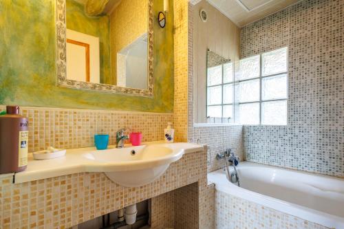 a bathroom with a sink and a tub and a mirror at Le Guiguet - Mas provençal avec piscine pour 10 in Vedène