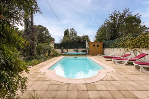 une piscine avec deux chaises et une table dans l'établissement Le Guiguet - Mas provençal avec piscine pour 10, à Vedène