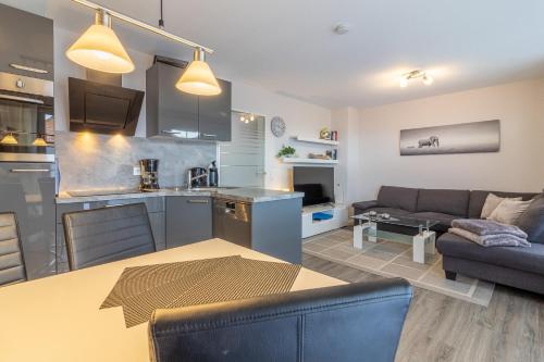 a kitchen and living room with a couch and a table at Ferienwohnung Ebbe in Hooksiel