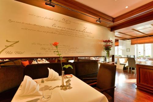 a dining room with a table and a wall with signatures at Hotel Adler Asperg in Asperg