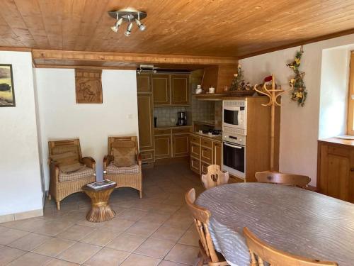 une cuisine avec une table et des chaises dans une pièce dans l'établissement Chalet 18 personnes 8 chambres aux 3 vallees, menuires, à Saint-Marcel