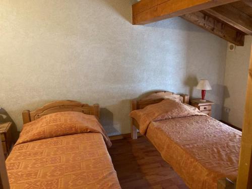zwei nebeneinander stehende Betten in einem Schlafzimmer in der Unterkunft Chalet 18 personnes 8 chambres aux 3 vallees, menuires in Saint-Marcel