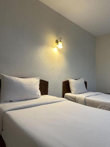 two beds sitting next to each other in a room at ปะการังแมนชั่น in Udon Thani