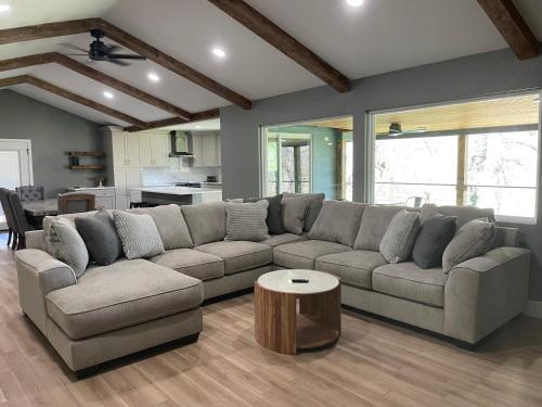 a living room with a large couch and a table at Farm House with River Access to Guadalupe River in New Braunfels