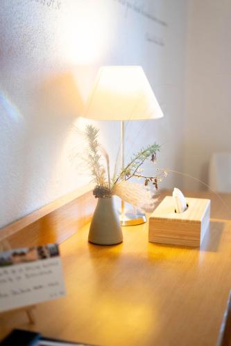 a lamp on a desk with a book and a plant at La Saline Royale in Arc-et-Senans