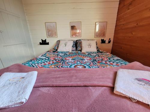 a bedroom with a bed with a colorful blanket on it at Bienvenue au CHAT LAIT ! in Seilhac