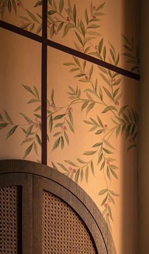 a wall with a painting of leaves on a wall at Hotel Certosa Di Maggiano in Siena