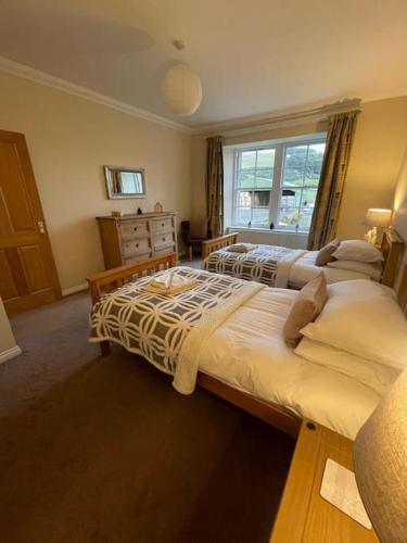 a bedroom with two beds and a window at The Furze Farmhouse near St Andrews in Newburgh