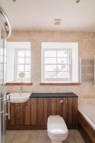 a bathroom with a toilet and a sink and a tub at The Furze Farmhouse near St Andrews in Newburgh