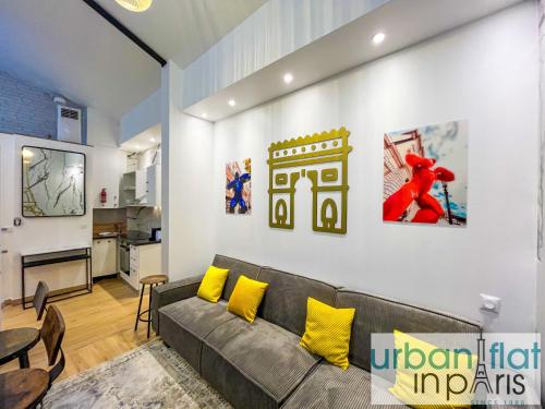 un salon avec un canapé gris et des coussins jaunes dans l'établissement 190 - Loft Gaite-Montparnasse, à Paris