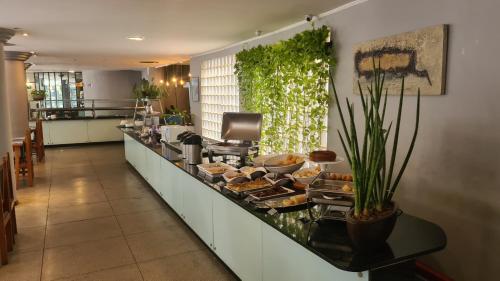 una linea a buffet in una cucina con cibo di Realminas Hotel e Restaurante a Governador Valadares