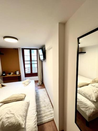 une chambre avec deux lits et un miroir dans l'établissement Les chambres de la bastide - 204, à Carcassonne