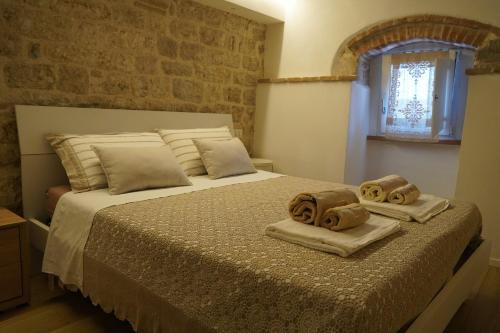 a bedroom with a bed with towels on it at Appartamento Gattapone 9 in Gubbio