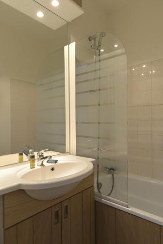 une salle de bain avec un lavabo et une douche dans l'établissement Hôtel Club mmv Les Brévières ****, à Tignes