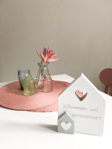 a table with a vase with a flower in it at Ruhiges Apartment Münster Baumberge in Nottuln