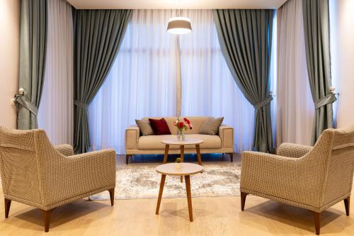 a living room with a couch and two chairs and a table at Dreamland Golf Hotel Baku in Baku