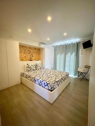 a bedroom with a bed and a large window at 818 Centro Náutico Bungalows in Vila Real de Santo António