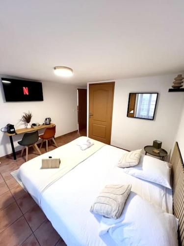 une chambre d'hôtel avec deux lits et un bureau dans l'établissement Les chambres de la bastide - 205, à Carcassonne