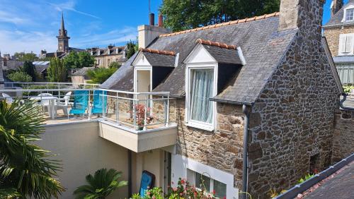une maison en pierre avec un balcon et une piscine dans l'établissement Clos de la Fontaine, à Dinard