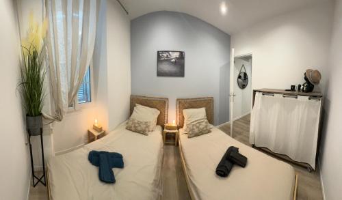 Cette petite chambre comprend 2 lits jumeaux. dans l'établissement Cocon Bohème Cannes Croisette-Palais-Plages 200m, à Cannes