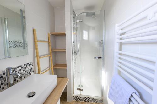 a white bathroom with a shower and a sink at Grand Appartement avec Balcon Hyper - Centre Tarbes in Tarbes