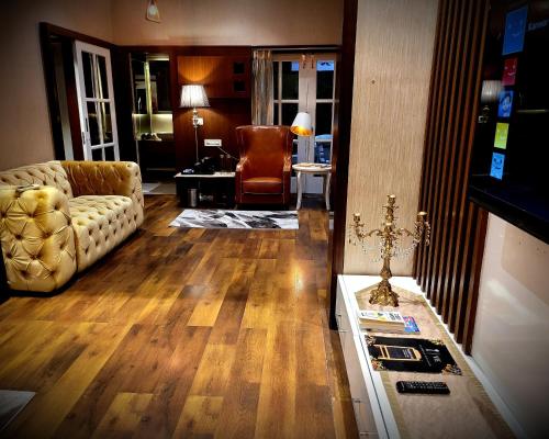 a living room with a couch and a chair at Victorian Elegance Luxury Stays in Amritsar