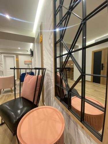 a room with a chair and a table and a mirror at Nebula Apartments in Tirana