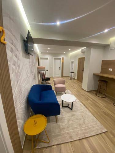 a living room with a blue chair and a table at Nebula Apartments in Tirana