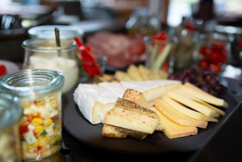 a plate of cheese and other foods on a table at Das.Hochgrat in Oberstaufen