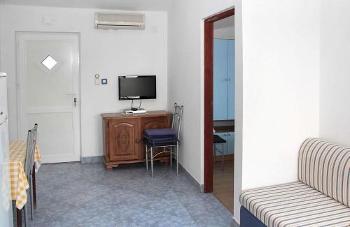 a living room with a tv and a table with a chair at Apartments Vink in Vir