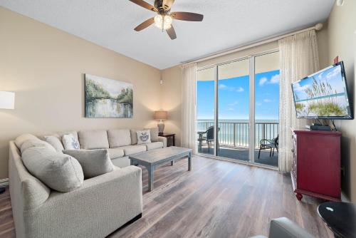 a living room with a couch and a large window at Spanish Key Unit 602 in Pensacola