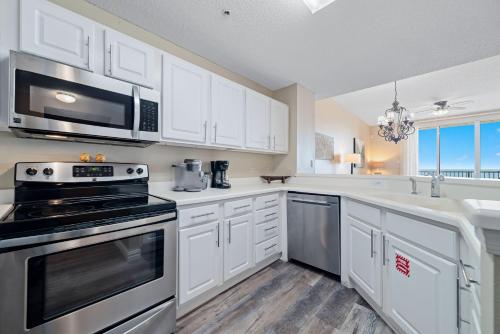a kitchen with white cabinets and a stove top oven at Spanish Key Unit 602 in Pensacola
