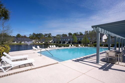 a swimming pool with lounge chairs and a pavilion at Mariners Getaway in Saint Simon Mills