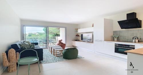 un salon avec un canapé bleu et une cuisine dans l'établissement Genêts - 47m2 - 4 pers - Cozy - Climatisé, au Cannet