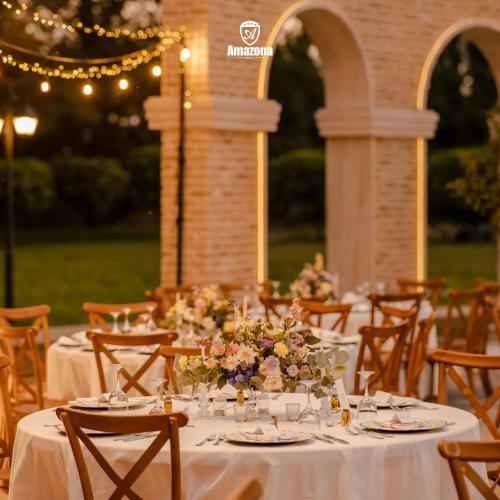 a table set up for a wedding with white tables and chairs at Amazona Hotel in Pristina