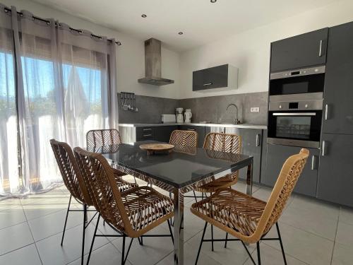 a kitchen with a dining room table and chairs at Résidence Storia di Blue in Porto-Vecchio
