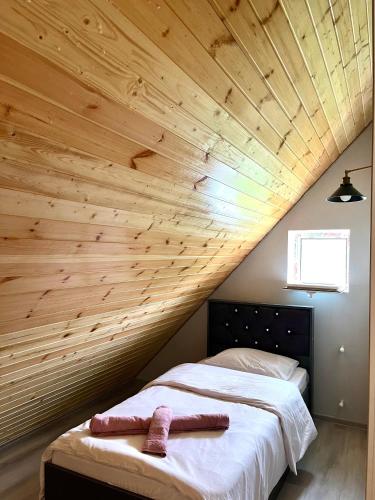 a bed in a room with a wooden ceiling at A Frame Villa Gabala in Gabala