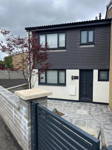 a black and white house with a black door at Uber Stylish 3 bedroom home off Road parking near town centre and Bike Park Wales in Merthyr Tydfil