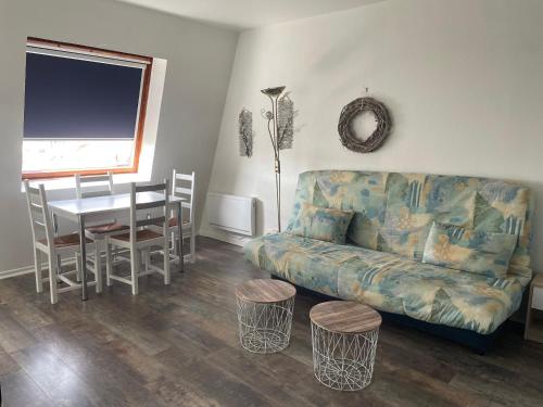 a living room with a couch and a table at Grand studio Centre-ville avec ascenseur in Calais