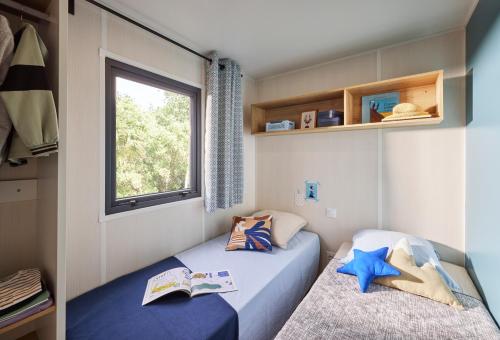 Domaine de l'Epinette في Châtillon: سريرين في غرفة صغيرة بها نافذة