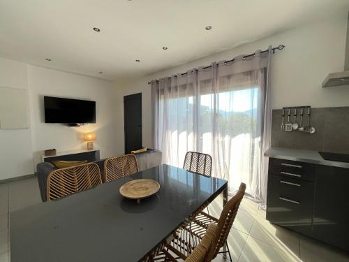 a kitchen and living room with a table and chairs at Résidence Storia di Blue in Porto-Vecchio