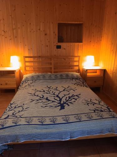 a bed in a wooden room with two lamps at La Casa Antica in Pont-Saint-Martin