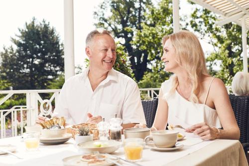 a man and a woman sitting at a table at Seehotel Maria Laach in Maria Laach