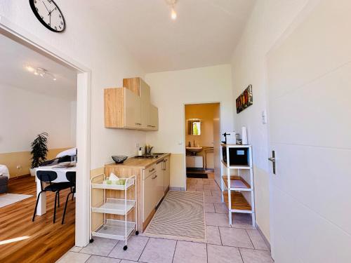 a kitchen and living room with a counter and a clock on the wall at Apartment Miramare in Neunkirchen