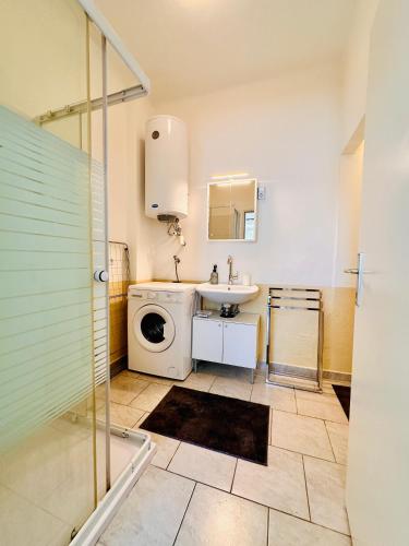 a bathroom with a washing machine and a sink at Apartment Miramare in Neunkirchen