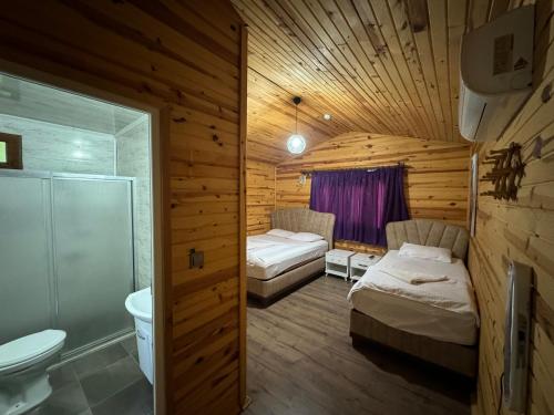 a bedroom with two beds and a bathroom with a toilet at mercan pension in Olympos