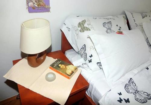 a bed with a lamp and a book on a night stand at Apartment Ljubav in Makarska