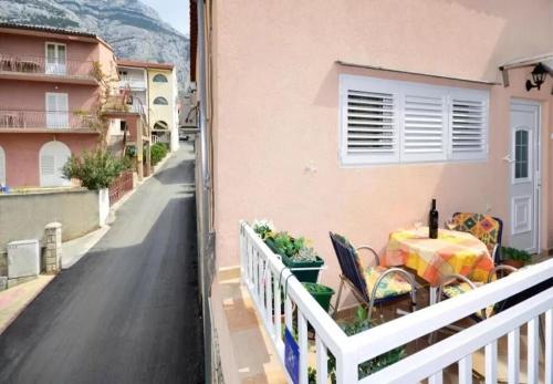 a balcony of a house with a table and a fence at Apartment Ljubav in Makarska