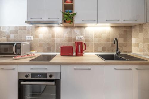 a kitchen with white cabinets and a sink at Apartment Ljubav in Makarska